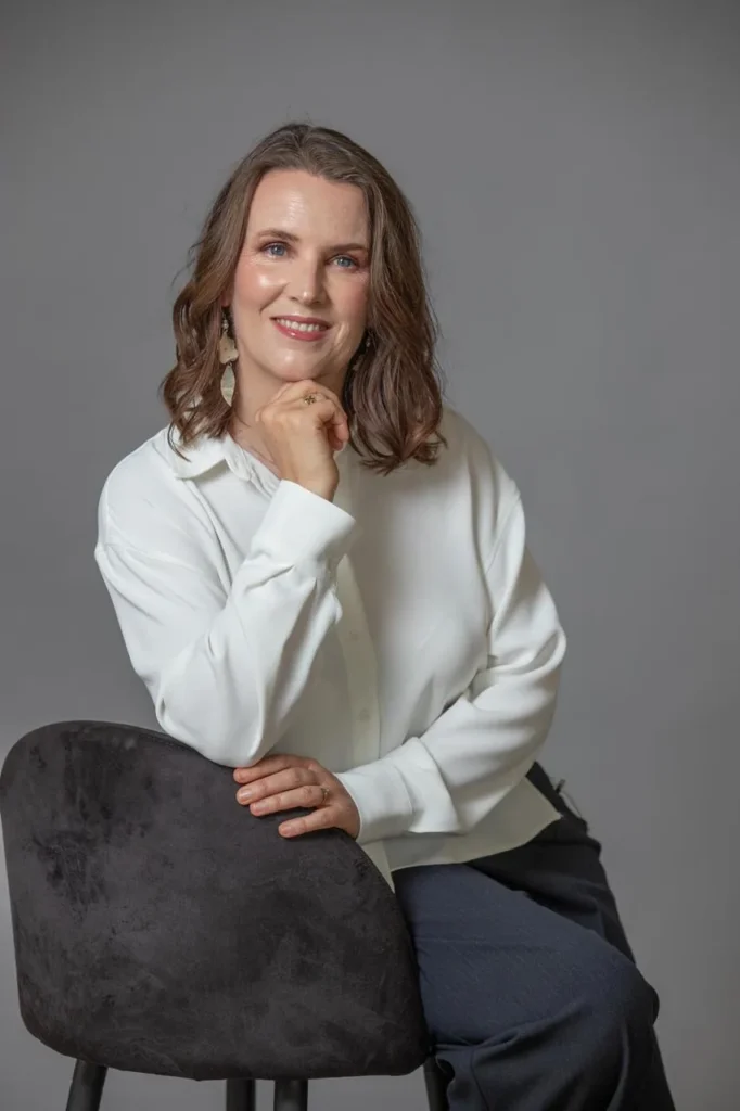 Cecilia Pederzolli sentada con camisa blanca, retrato de estudio