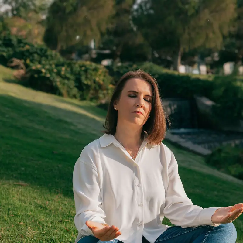 Cecilia Pederzolli meditando sentada sobre el pasto