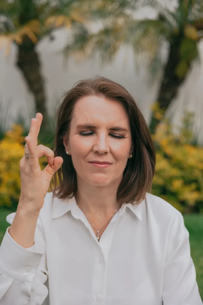 Cecilia Pederzolli con los ojos cerrados y la mano en gesto de meditación